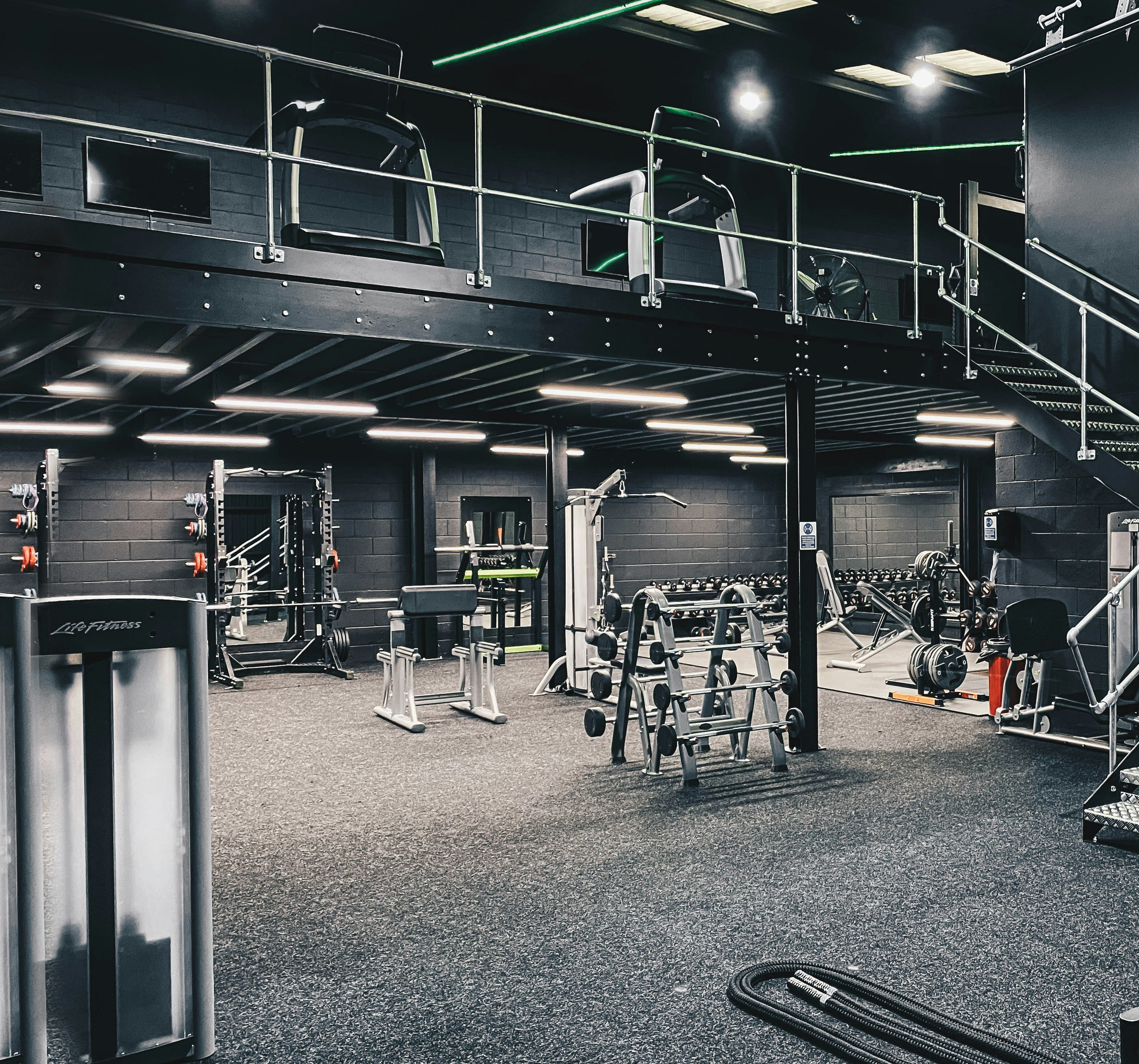 A large, well lit gym space stocked with a variety of clean equipment and machines